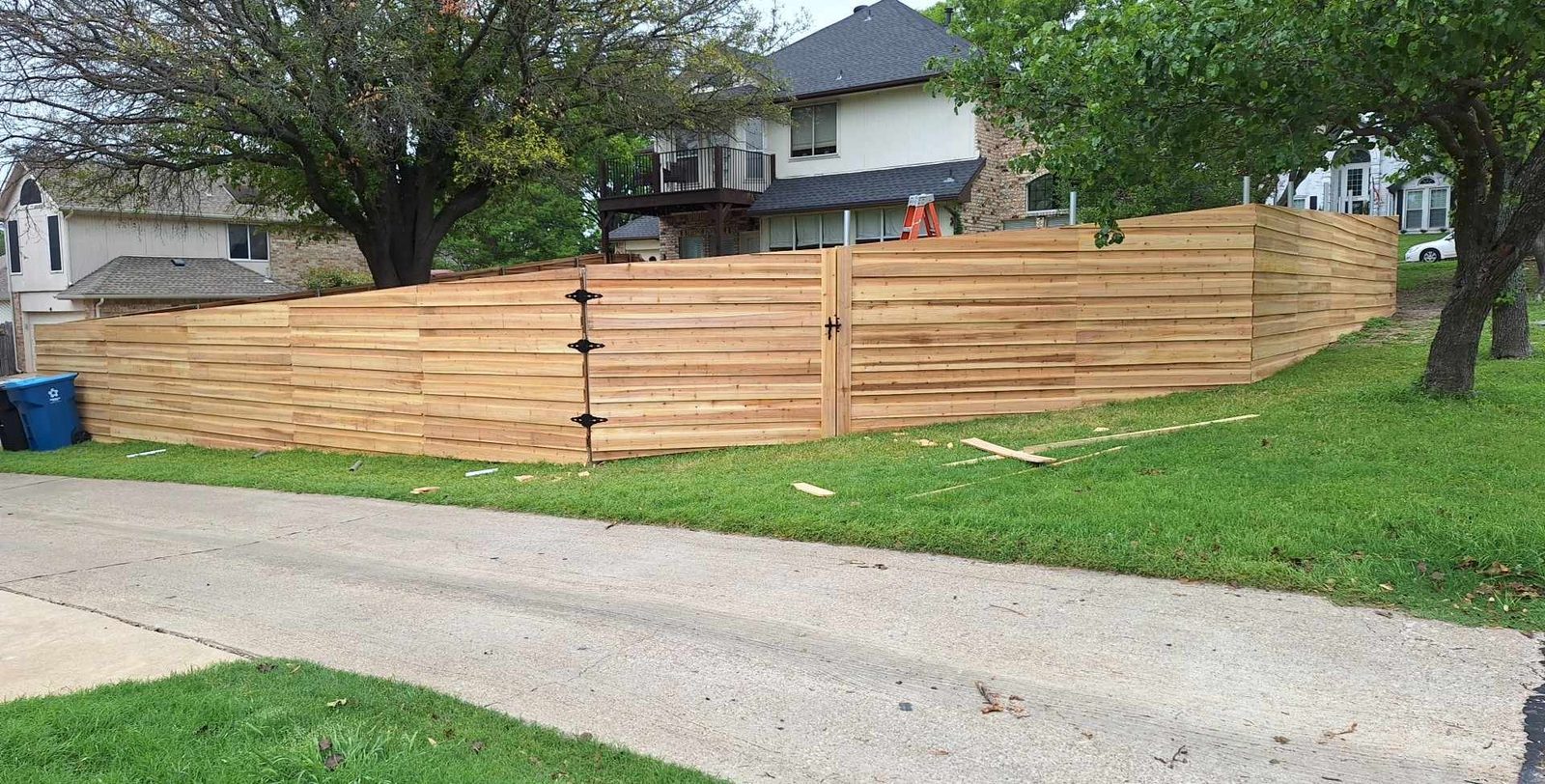 Horizontal cedar fence with gate stepped down a sloped front yard