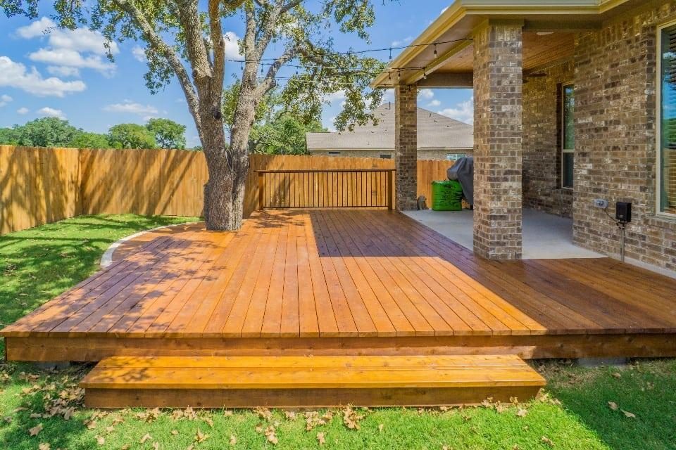 Custom stained cedar deck wrapping around a tree with steps